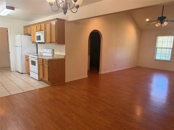 a view of kitchen with stainless steel appliances granite countertop a stove top oven a sink and dishwasher with wooden floor
