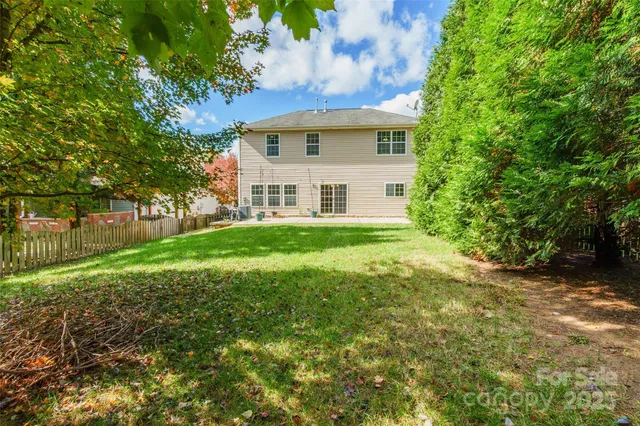 a view of a house with backyard and trees