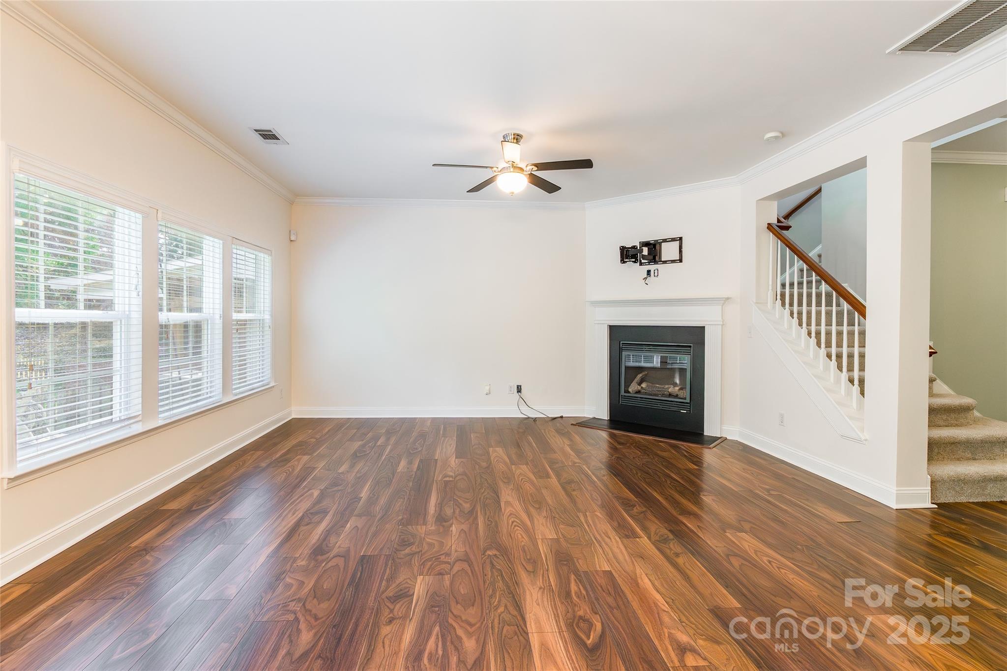 9312 Seamill Road Charlotte, NC 28278 - Photo 7 of 30 an empty room with wooden floor fireplace and windows