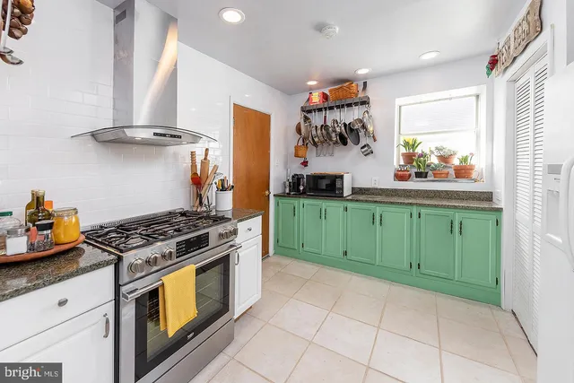 a kitchen with stainless steel appliances granite countertop a stove a sink and a refrigerator