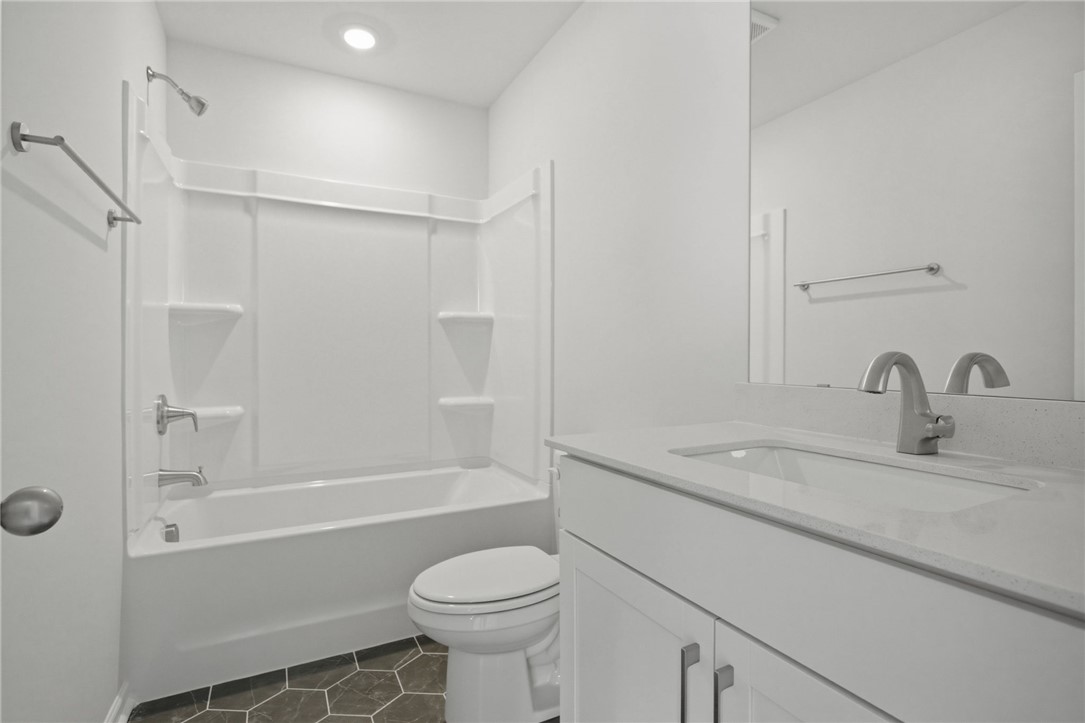 557 Hydrangea Street, Unit LOT 46 Seneca, SC 29678 - Photo 26 of 37 White fixtures and hex tile flooring create a contemporary and clean bathroom space.