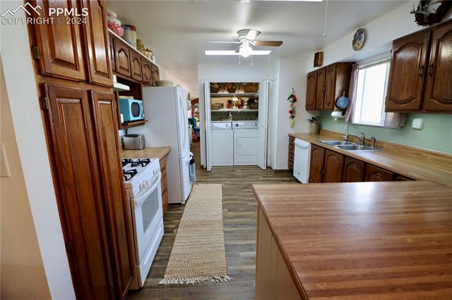 7 Bluff Road Florence, CO 81226 - Photo 6 of 29 Kitchen with white appliances, ceiling fan, dark wood-type flooring, sink, and independent washer and dryer