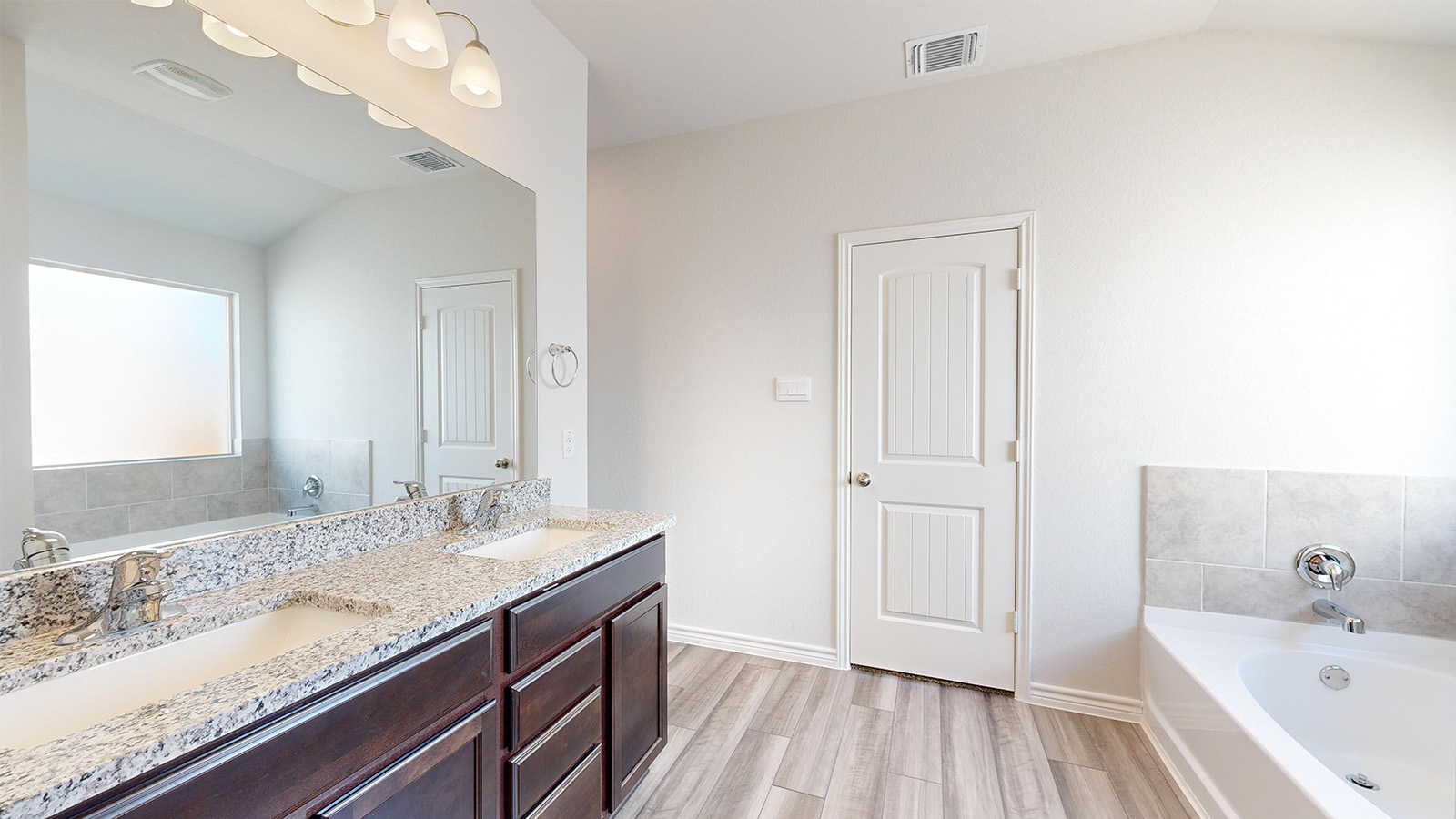 238 Water Wl Road Burnet, TX 78611 - Photo 14 of 33 Bathroom featuring a garden tub, lofted ceiling, double vanity, and light wood-style floors