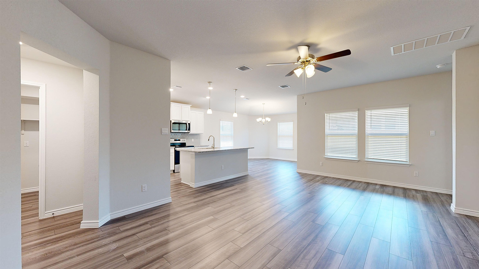 238 Water Wl Road Burnet, TX 78611 - Photo 2 of 33 Unfurnished living room with a chandelier, a ceiling fan, and light wood-style floors