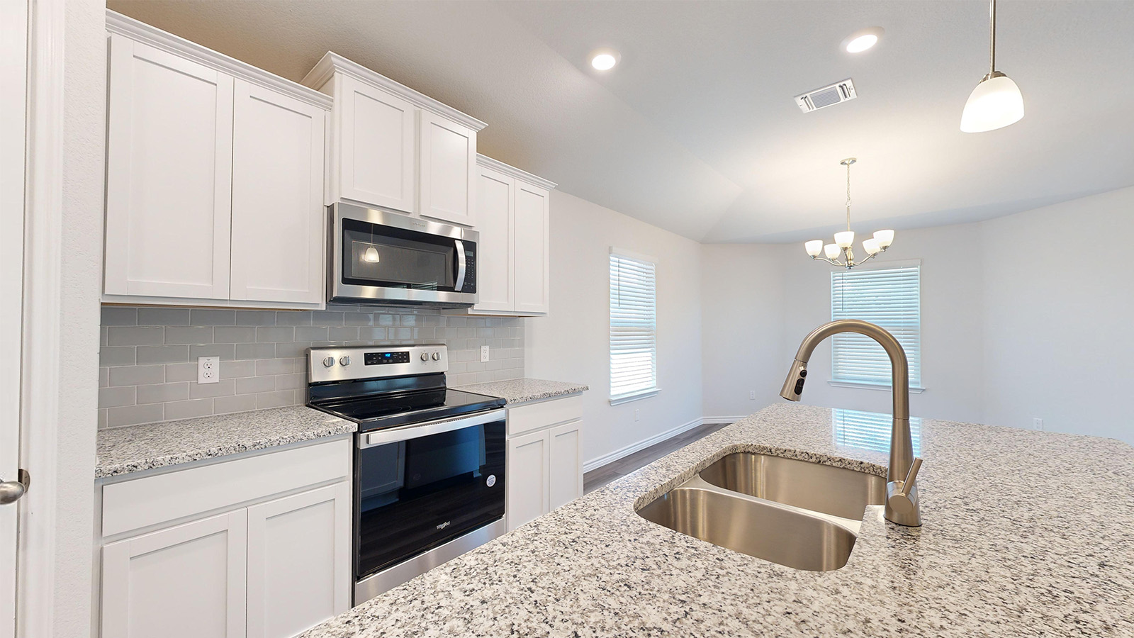 238 Water Wl Road Burnet, TX 78611 - Photo 4 of 33 Kitchen featuring stainless steel appliances, white cabinetry, backsplash, light stone countertops, and hanging lights