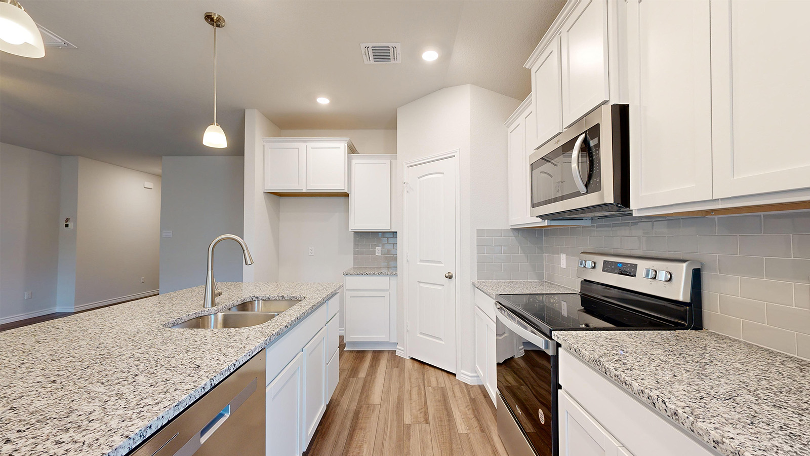 238 Water Wl Road Burnet, TX 78611 - Photo 5 of 33 Kitchen with stainless steel appliances, light wood-style floors, white cabinets, tasteful backsplash, and pendant lighting