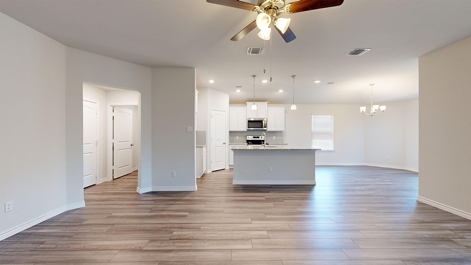 238 Water Wl Road Burnet, TX 78611 - Photo 31 of 33 Kitchen featuring open floor plan, ceiling fan, a center island with sink, white cabinets, and light wood-style floors