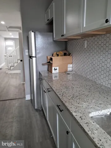 a view of an empty room with wooden floor & closet