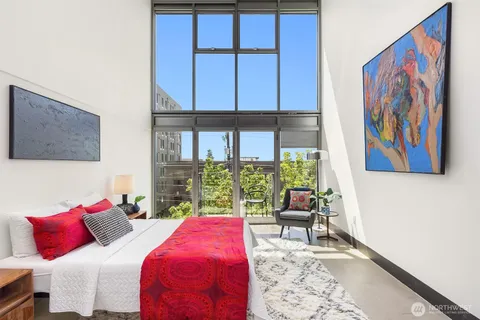 a bedroom with a bed and a painting on the wall