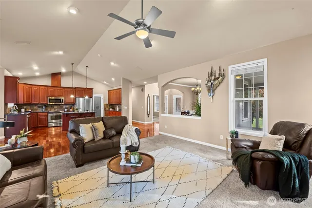 a kitchen with stainless steel appliances granite countertop a stove top oven a sink dishwasher a dining table and chairs with wooden floor