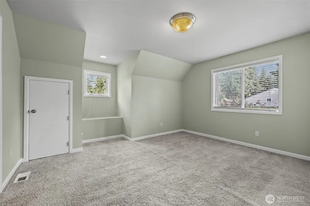 a view of a house with a barbeque and wooden bench