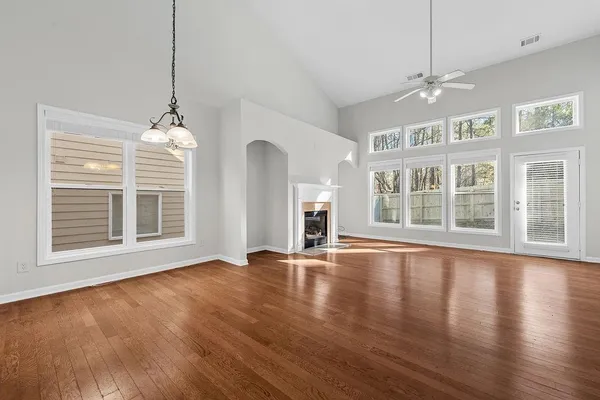 a view of empty room with wooden floor and fan