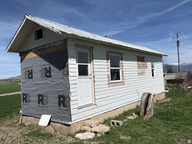 5790 North 6850th W Cache Junction West Cache Junction, UT 84304 - Photo 21 of 24 View of property exterior with a yard and a metal roof