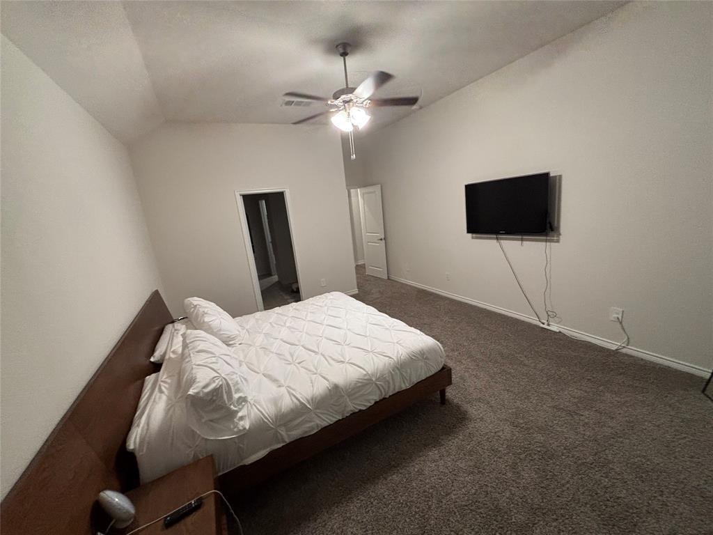 10512 Autumn Leaves Lane Aubrey, TX 76227 - Photo 6 of 9 a bedroom with a bed and a flat screen tv