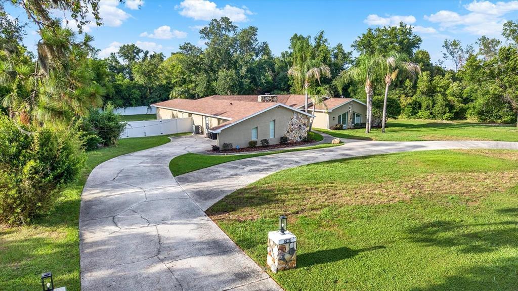 7487 River Country Drive Weeki Wachee, FL 34607 - Photo 6 of 53 a front view of a house with a yard and trees