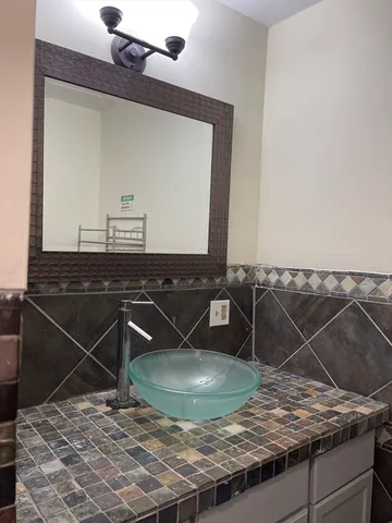 a bathroom with a granite countertop sink and a mirror