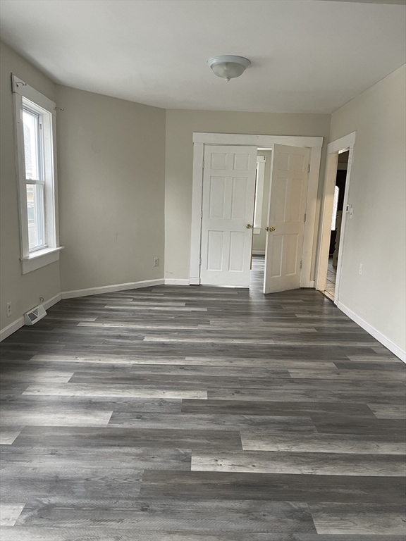 67-69 Loring Street Lowell, MA 01851 - Photo 2 of 16 a view of an empty room with wooden floor and window