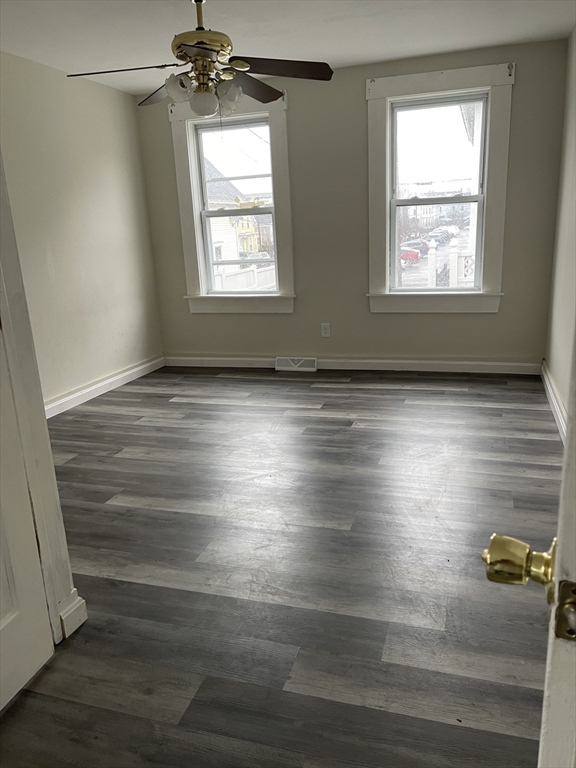67-69 Loring Street Lowell, MA 01851 - Photo 5 of 16 a view of empty room with wooden floor and fan
