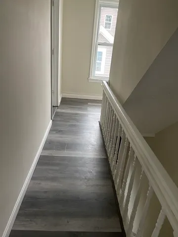 a view of entryway and hall with wooden floor