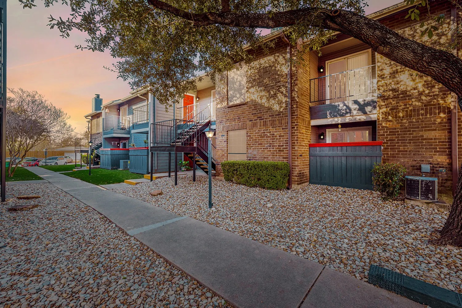6808 South I-35 Frontage Road, Unit 253 Austin, TX 78745 - Photo 5 of 21 Property exterior at dusk featuring a balcony and brick siding