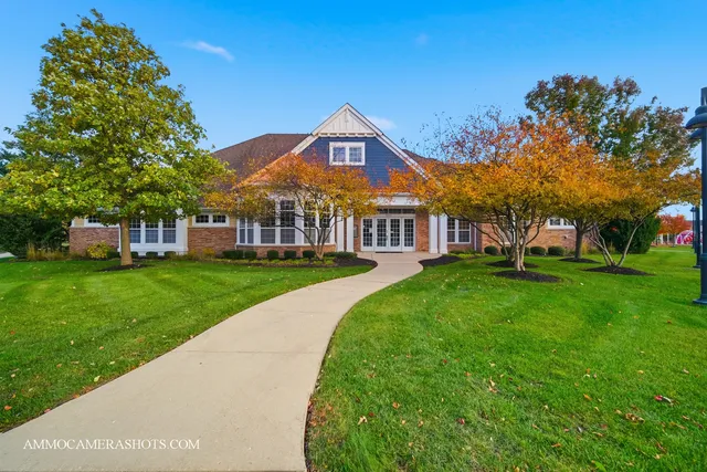 a view of a big yard in front of a brick house with a large tree