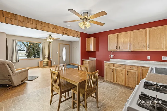 a kitchen with a refrigerator a stove a sink dishwasher with a dining table and chairs with wooden floor