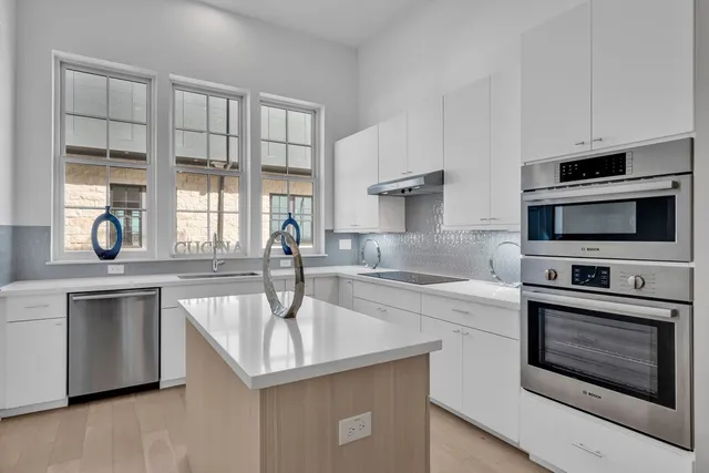 a kitchen with stainless steel appliances granite countertop a sink and a microwave