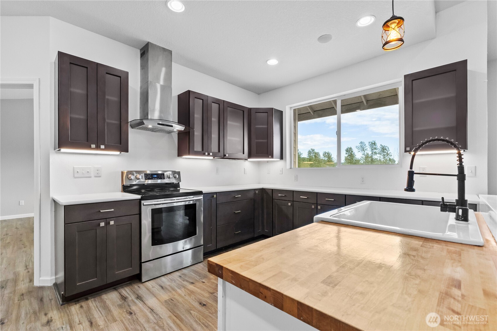249 Flatt Road Kelso, WA 98626 - Photo 11 of 39 a kitchen with stainless steel appliances granite countertop a sink a stove and a wooden floors