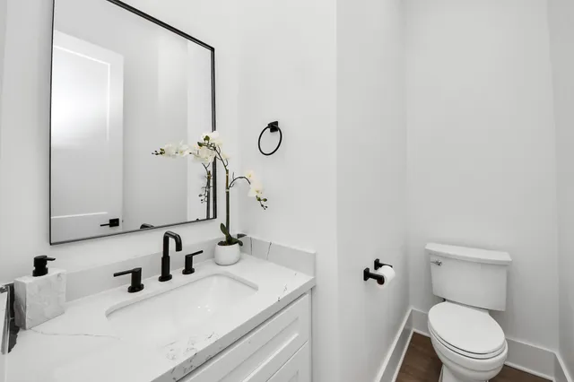 a bathroom with a sink vanity granite toilet and a mirror