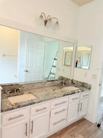 a bathroom with a granite countertop sink and a mirror