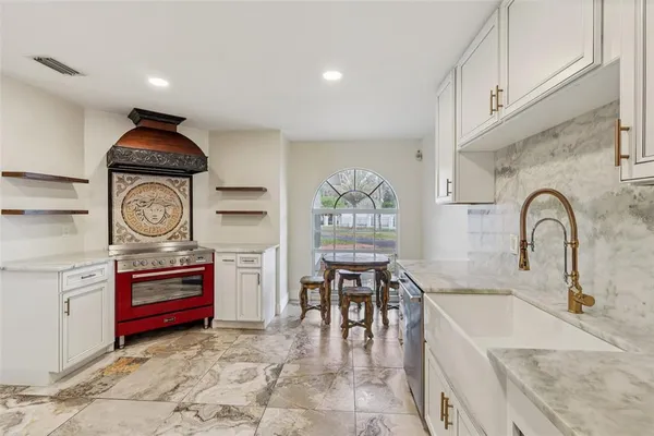 a kitchen with stainless steel appliances granite countertop a sink and a stove