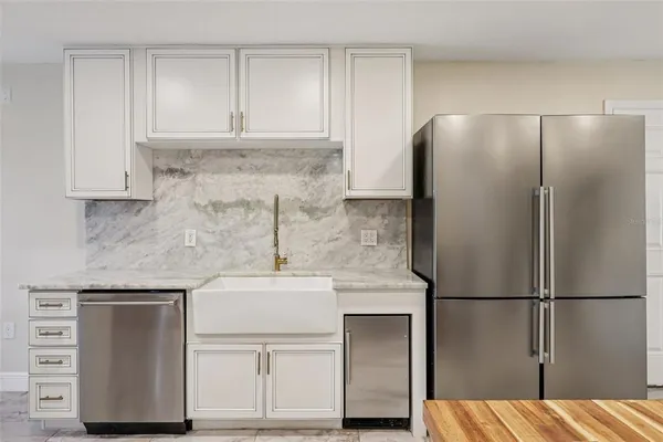 a kitchen with a refrigerator sink and cabinets