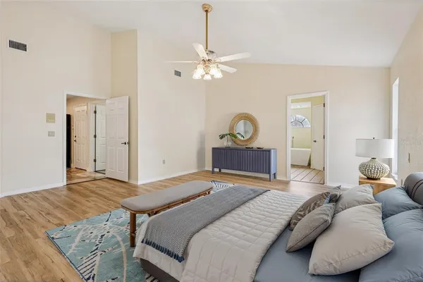 a bedroom with a large bed and a chandelier