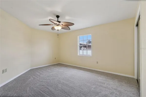 a view of a room with a ceiling fan and a window