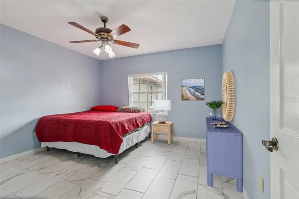 a spacious bedroom with a bed and a chandelier