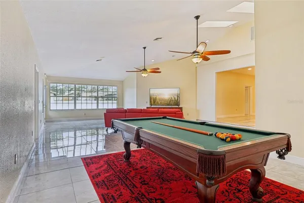 a room with pool table and windows