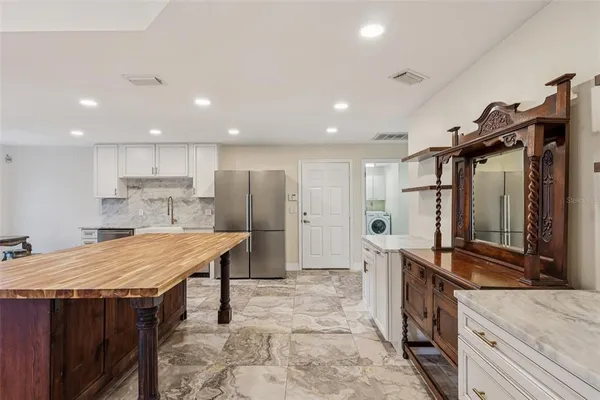 a kitchen with stainless steel appliances granite countertop a sink refrigerator and cabinets