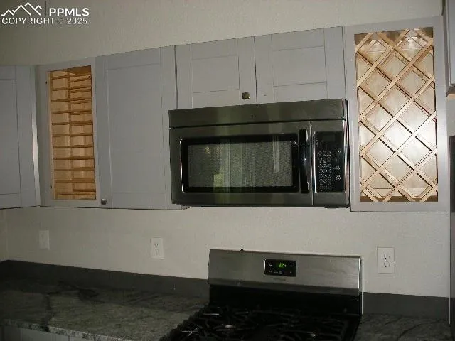 a kitchen with granite countertop white cabinets and black appliances