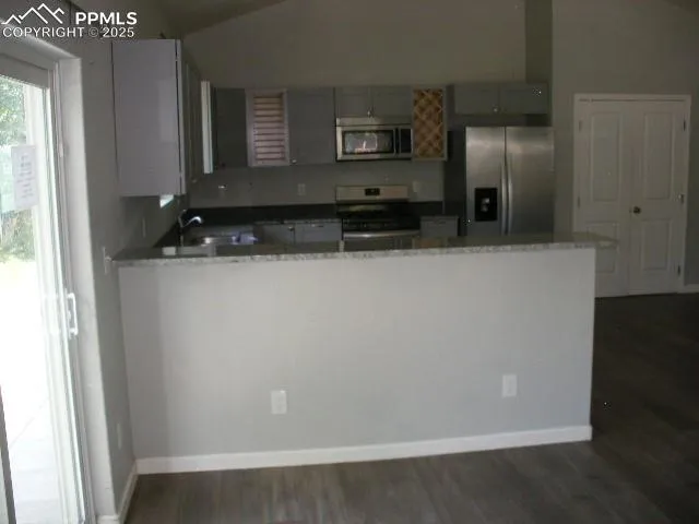 a view of a refrigerator in kitchen and wooden floor