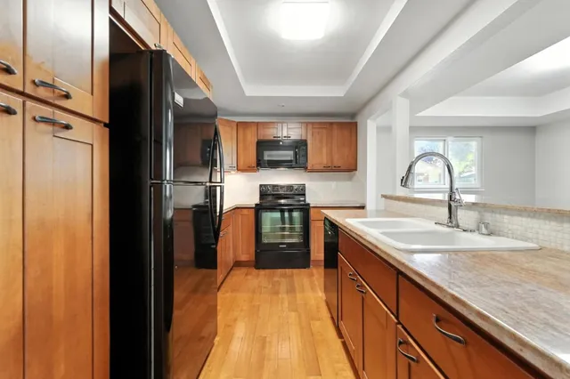 a kitchen with granite countertop a sink stove and refrigerator