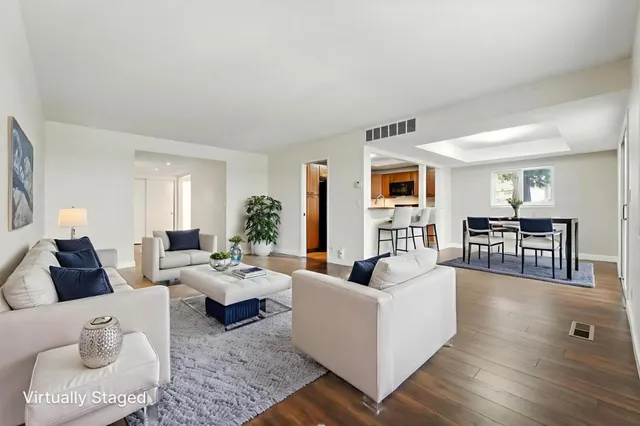 a living room with furniture wooden floor and a large window