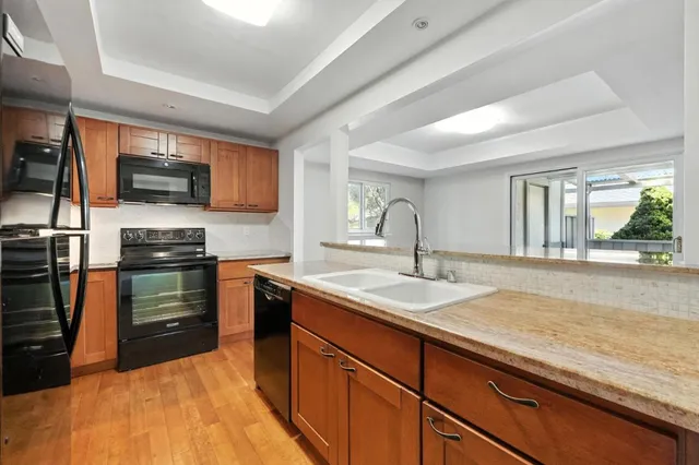 a kitchen with granite countertop a sink and a stove top oven
