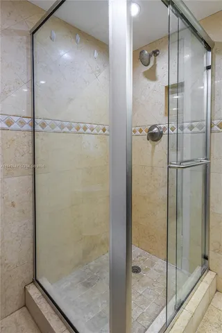 an empty room with chandelier fan and windows