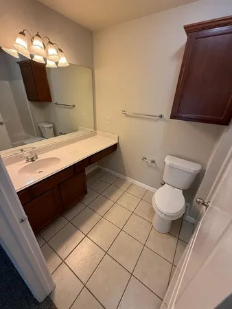 a bathroom with a sink mirror vanity and toilet