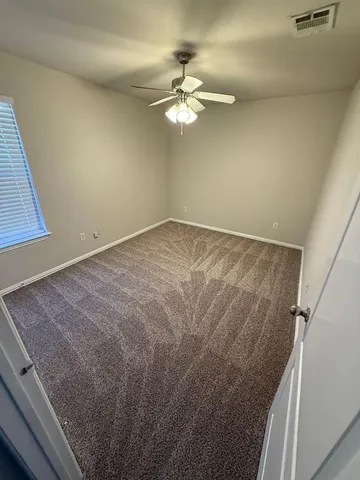 a view of a room with a ceiling fan and a hardwood