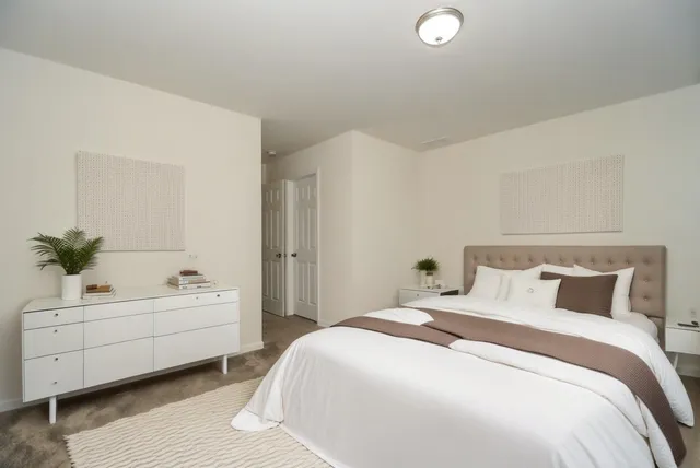 a bedroom with a white bed and a couch