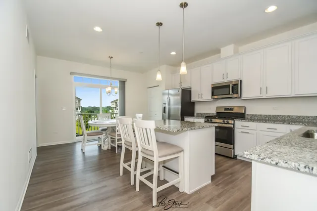 a view of kitchen with microwave stove top oven and cabinets