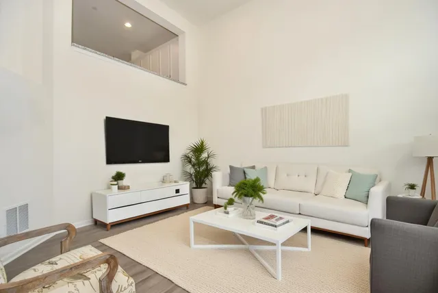 a living room with furniture a flat screen tv and couches