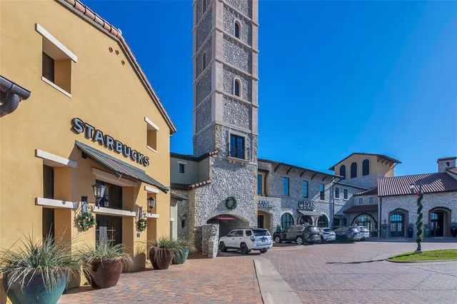 a front view of a building with cars parked