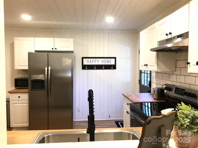 a kitchen with stainless steel appliances kitchen island granite countertop a refrigerator and a stove